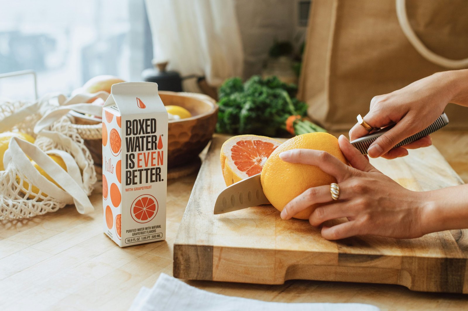 a person cutting an orange on a cutting board